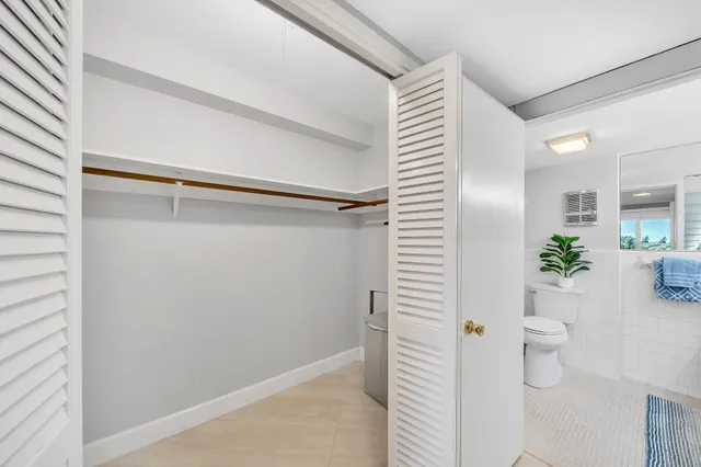 a bathroom with a white shower curtain and a potted plant