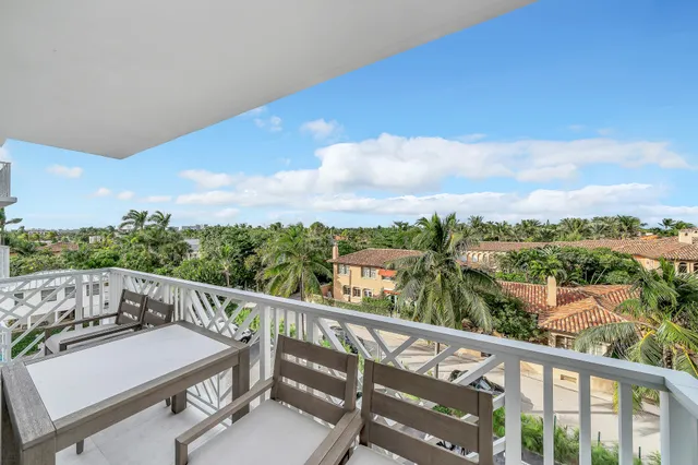 a view of a city from a balcony with furniture