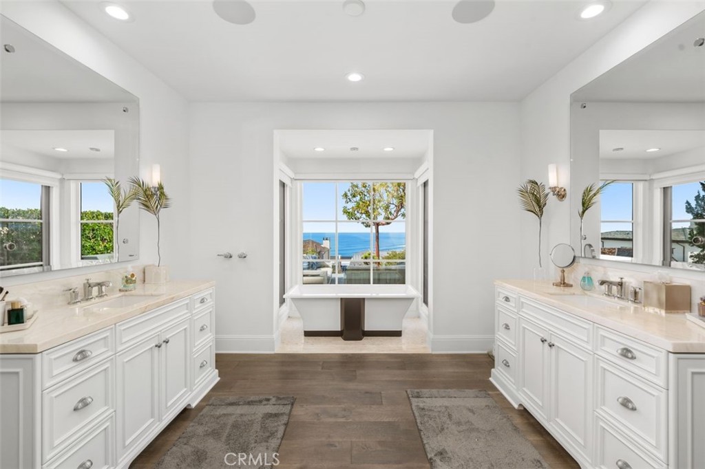 19 Seabreeze Terrace Dana Point, CA 92629 - Photo 22 of 40 a bathroom with a double vanity sink a large mirror and a bathtub next to a window