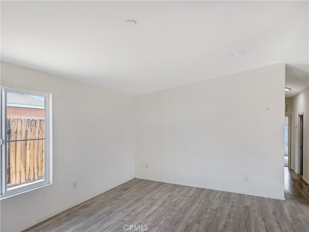 17647 Palowalla Road Blythe, CA 92225 - Photo 8 of 23 an empty room with wooden floor and windows