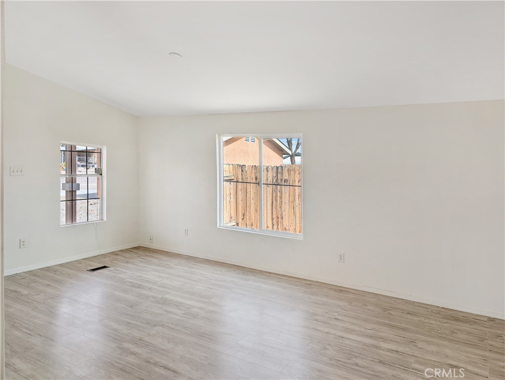 17647 Palowalla Road Blythe, CA 92225 - Photo 10 of 23 an empty room with wooden floor and windows
