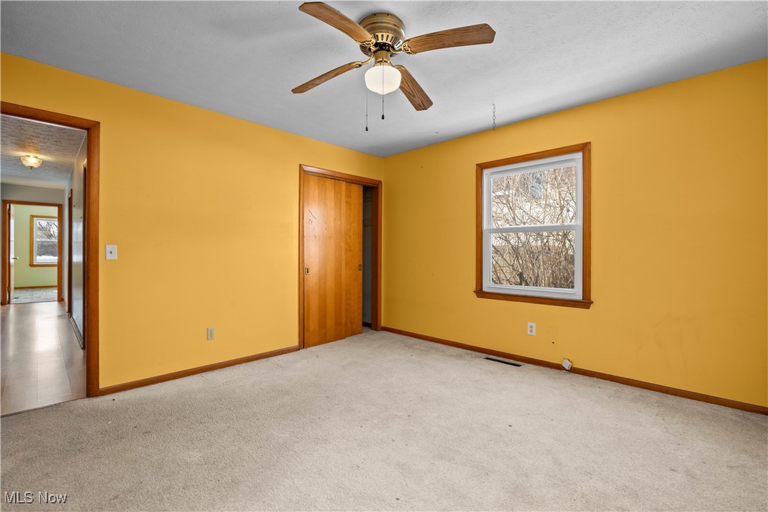 14015 West Lake Road Vermilion, OH 44089 - Photo 37 of 50 Unfurnished bedroom featuring carpet floors, a closet, and a ceiling fan