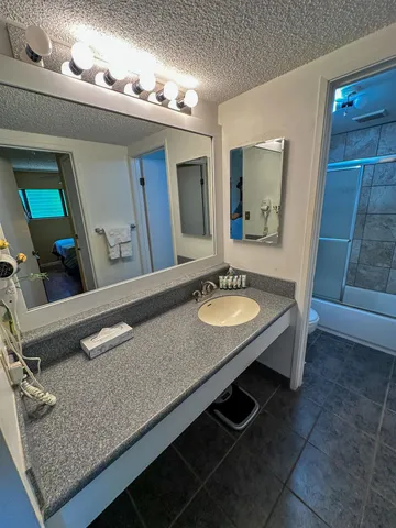 a bathroom with a granite countertop sink a mirror and a vanity