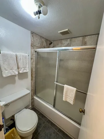 a white toilet sitting next to a shower