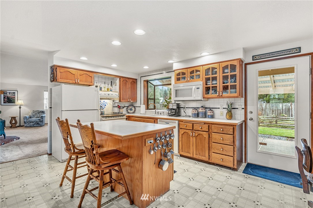 25431 Cromwell Road Monroe, WA 98272 - Photo 5 of 40 a kitchen with stainless steel appliances granite countertop a table chairs sink and cabinets