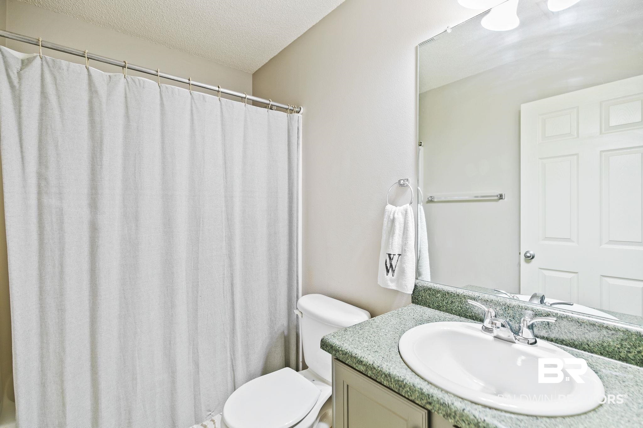 28246 Turkey Branch Drive Daphne, AL 36526 - Photo 23 of 41 Bathroom featuring a textured ceiling, vanity, and toilet