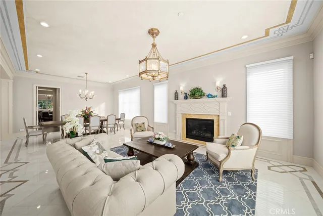 a living room with furniture a fireplace and a chandelier