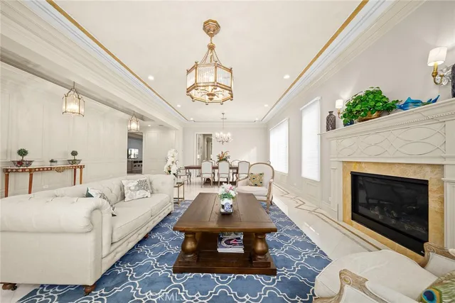 a living room with furniture a chandelier and a fireplace