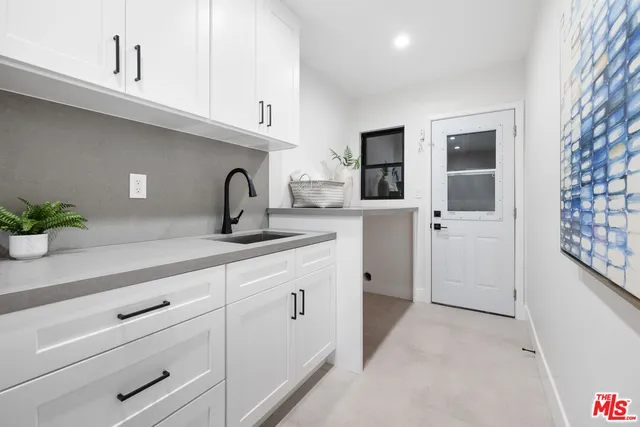 a kitchen with granite countertop a white cabinets and a sink