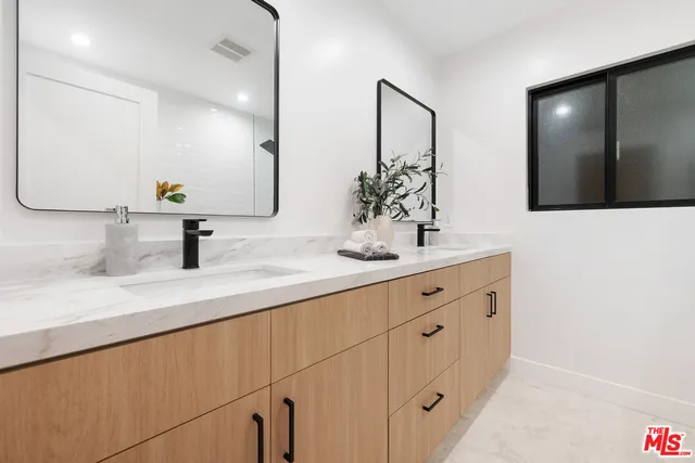 a bathroom with double sink and a mirror