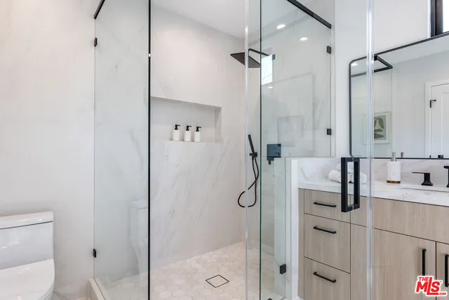 a bathroom with a shower sink vanity and toilet