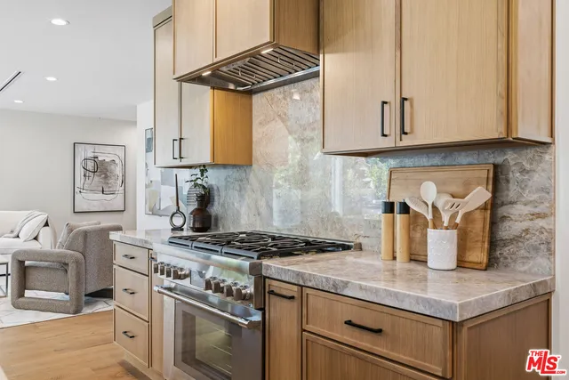 a kitchen with granite countertop a sink stove and cabinets