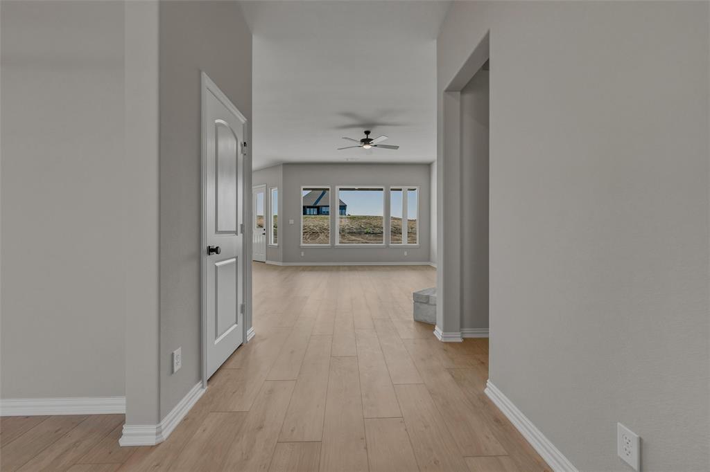 153 Big Sky Road Decatur, TX 76234 - Photo 9 of 38 Wood-finish flooring throughout, bright interior paint, multiple windows, and a ceiling fan
