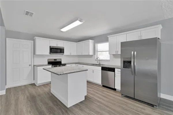 a kitchen with a refrigerator stove and microwave