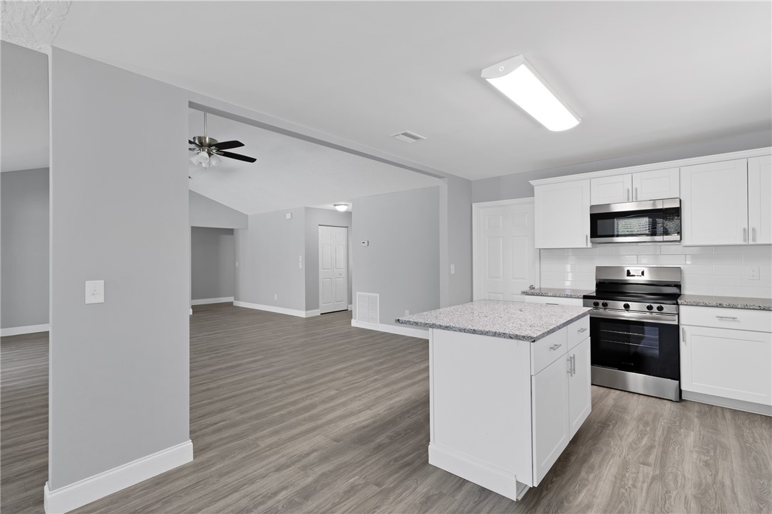 462 Watercrest Street Sebastian, FL 32958 - Photo 13 of 36 a kitchen with stainless steel appliances granite countertop a stove top oven a sink dishwasher and a refrigerator with wooden floor