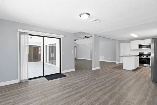 a view of a kitchen with wooden floor and electronic appliances