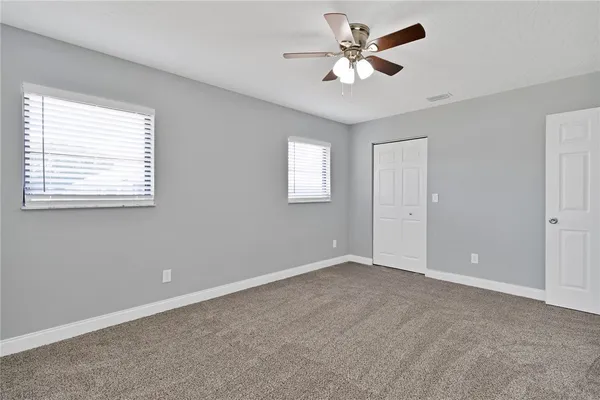 a view of an empty room with a ceiling fan and a window