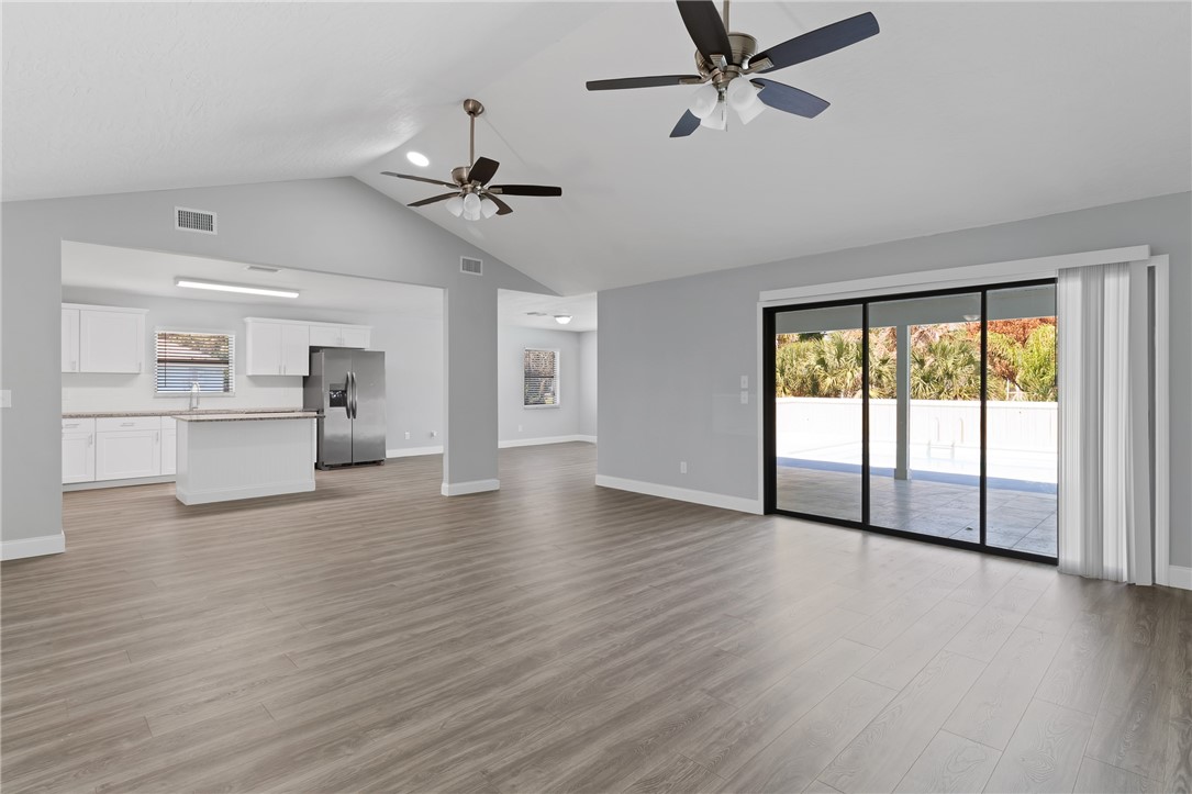 462 Watercrest Street Sebastian, FL 32958 - Photo 7 of 36 an empty room with wooden floor a ceiling fan and windows