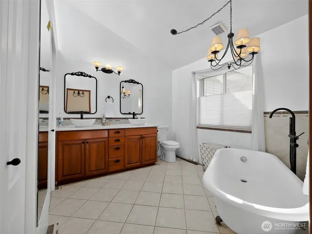a bathroom with a tub sink and mirror