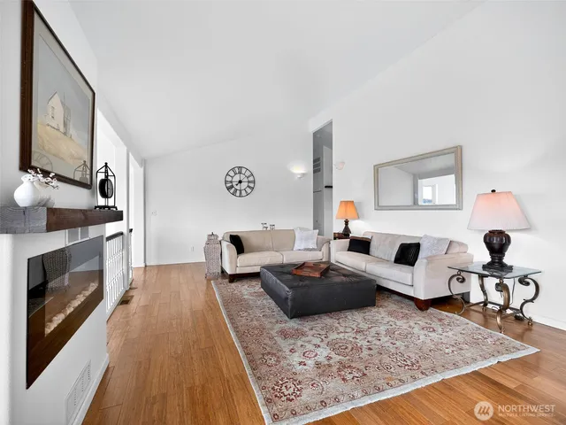 a living room with furniture hard wood floor and a fireplace