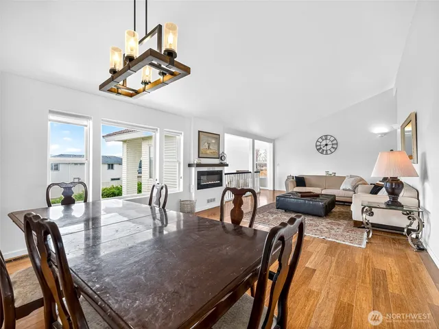 a view of a dining room with furniture a chandelier and wooden floor