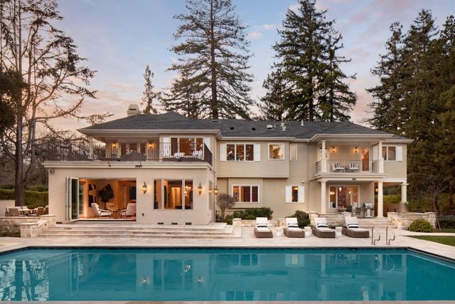 a front view of a house with a garden and sitting area