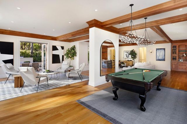 a living room with furniture a pool table and a flat screen tv