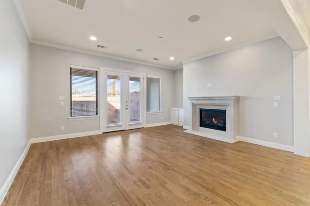 an empty room with wooden floor and fireplace