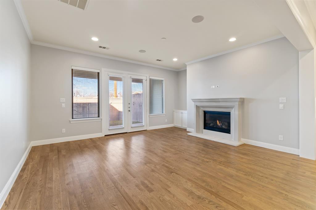 6531 Roper Street Dallas, TX 75209 - Photo 14 of 40 an empty room with wooden floor and fireplace