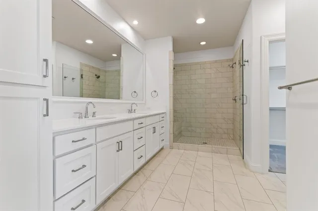 a spacious bathroom with a double vanity sink mirror and shower