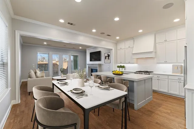 a kitchen with a dining table chairs and refrigerator