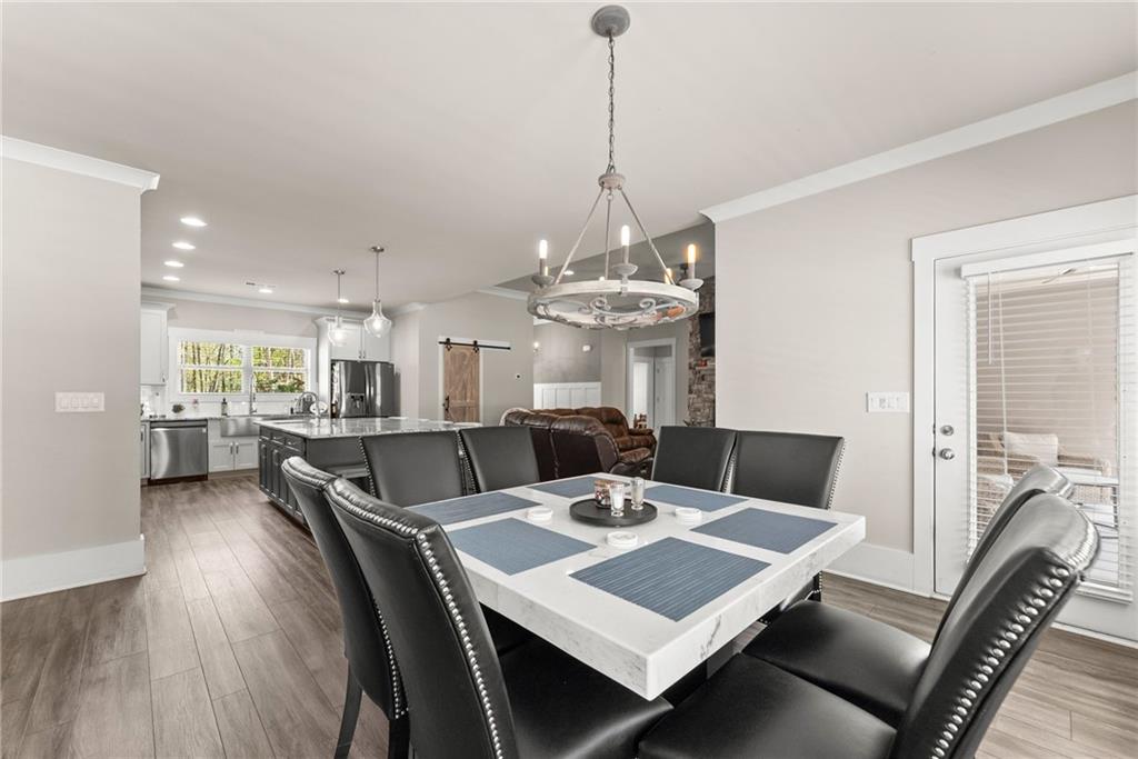 970 GA Highway 211 Winder, GA 30680 - Photo 20 of 60 a view of a dining room and livingroom with furniture wooden floor a rug a chandelier and a mirror