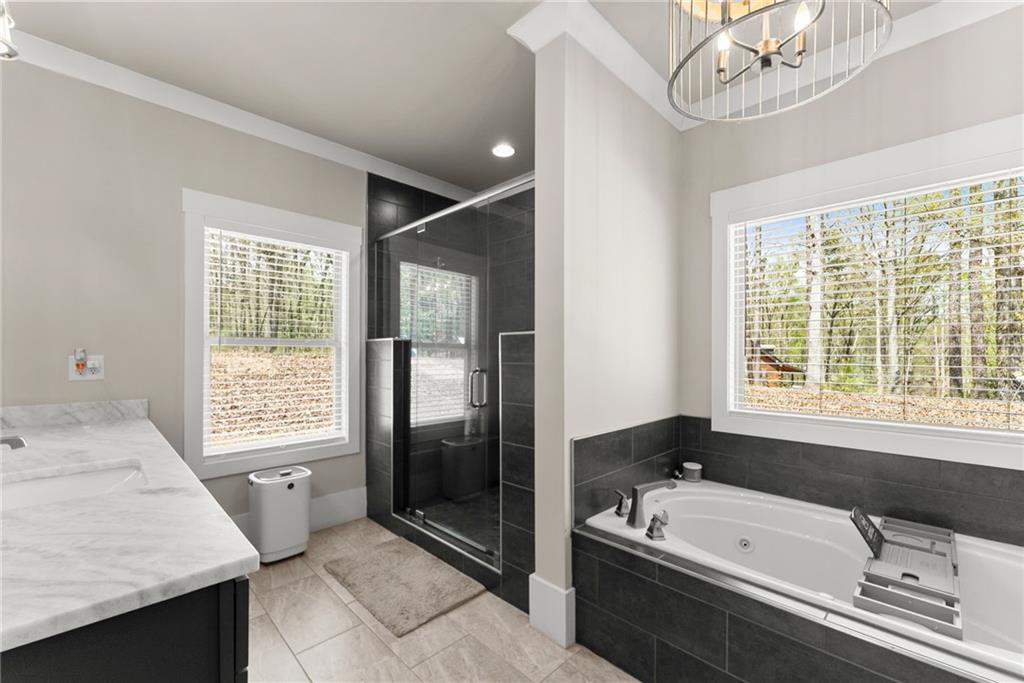 970 GA Highway 211 Winder, GA 30680 - Photo 26 of 60 a bathroom with a granite countertop tub a sink and a large mirror
