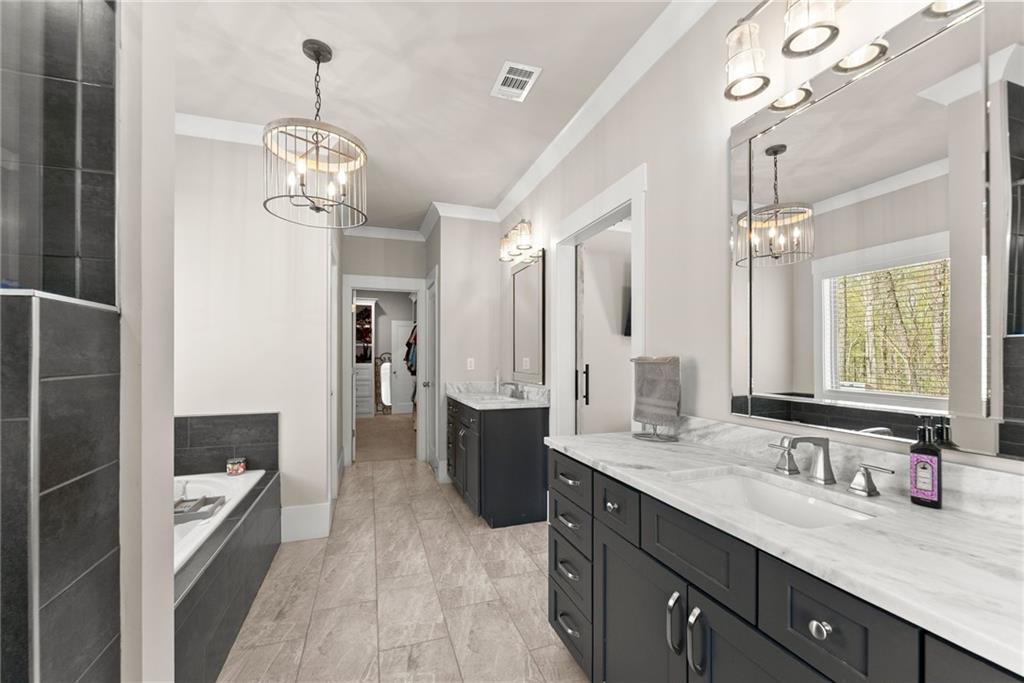 970 GA Highway 211 Winder, GA 30680 - Photo 28 of 60 a spacious bathroom with a granite countertop sink mirror and a shower