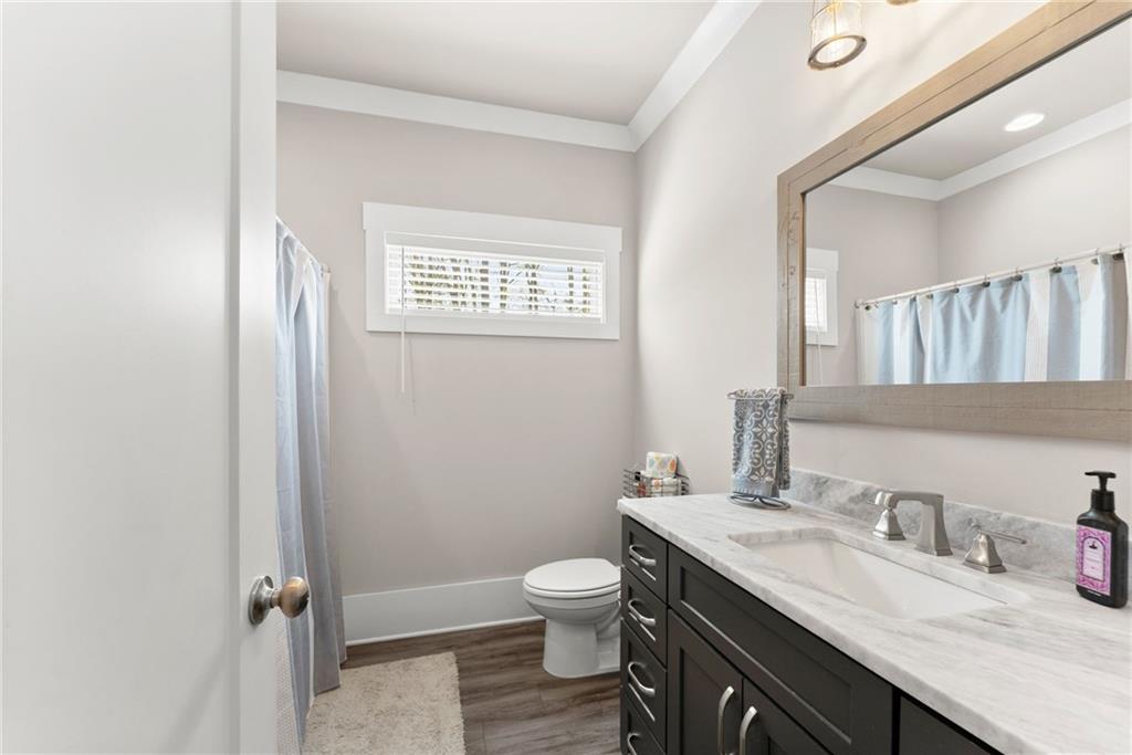 970 GA Highway 211 Winder, GA 30680 - Photo 39 of 60 a bathroom with a granite countertop toilet a sink and a mirror