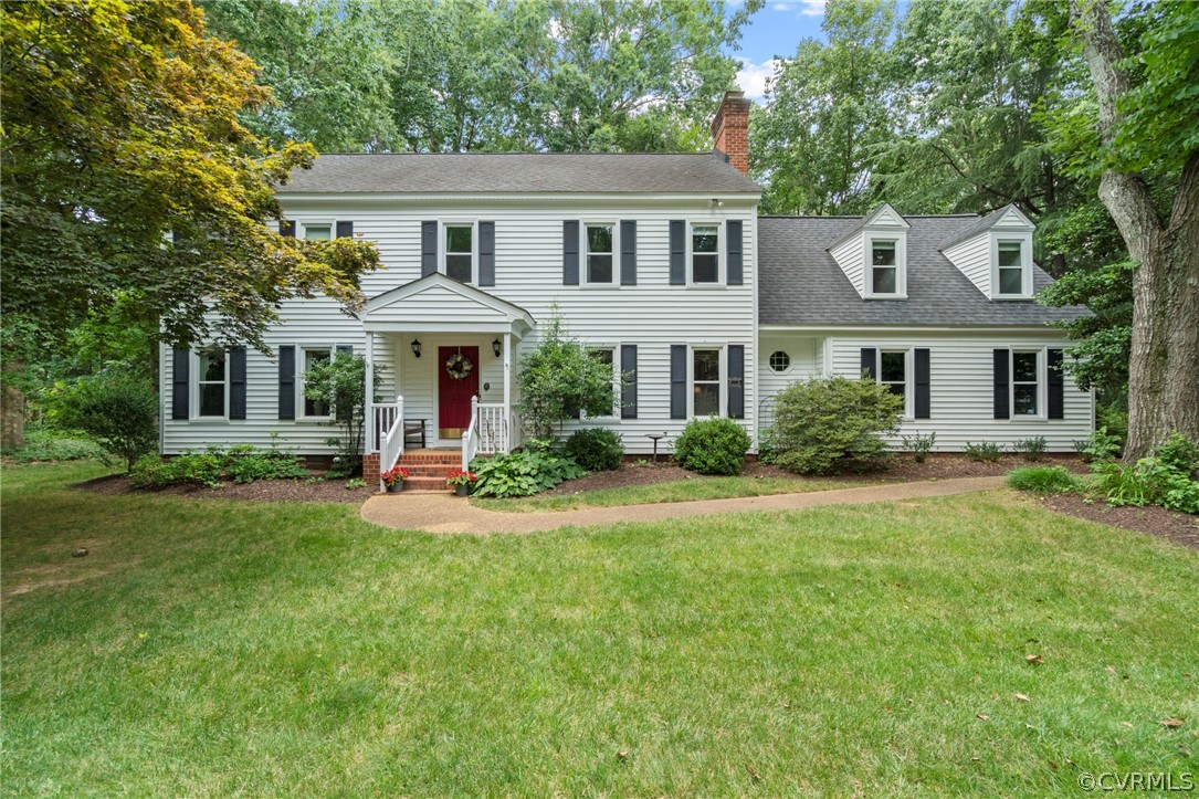a front view of a house with yard and green space