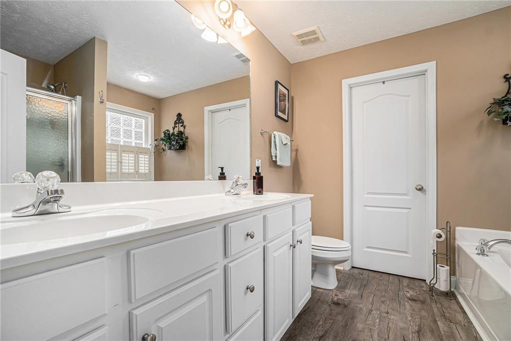 21 Cartee Lane Dallas, GA 30157 - Photo 20 of 29 a spacious bathroom with a double vanity sink a toilet and a mirror