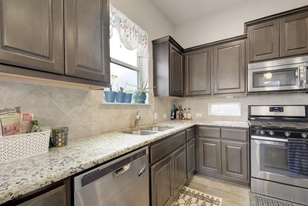 a kitchen with stainless steel appliances granite countertop a sink stove and cabinets
