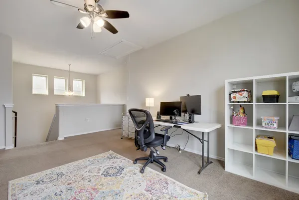 a view of a workspace with furniture and a window