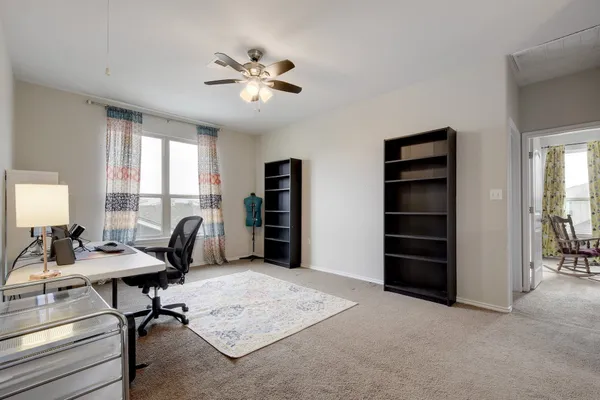 a view of a livingroom with workspace and a window