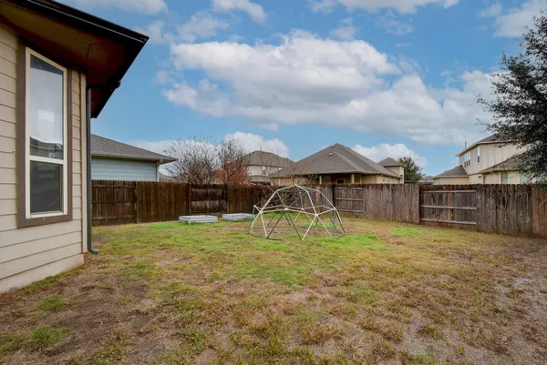 a backyard of a house with table and chairs