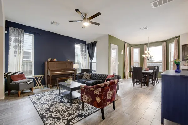 a living room with furniture a dining table and a piano table