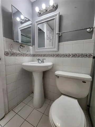 a view of an empty room with window and a kitchen