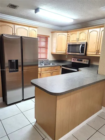 a kitchen with stainless steel appliances granite countertop a sink and a refrigerator