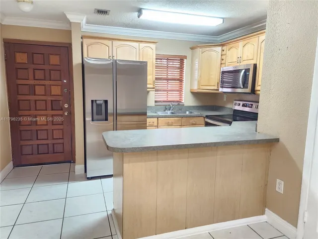 a kitchen with granite countertop a refrigerator and a sink