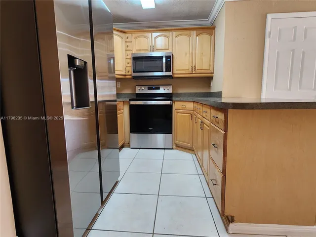 a kitchen with stainless steel appliances granite countertop a refrigerator a stove top oven a sink and dishwasher