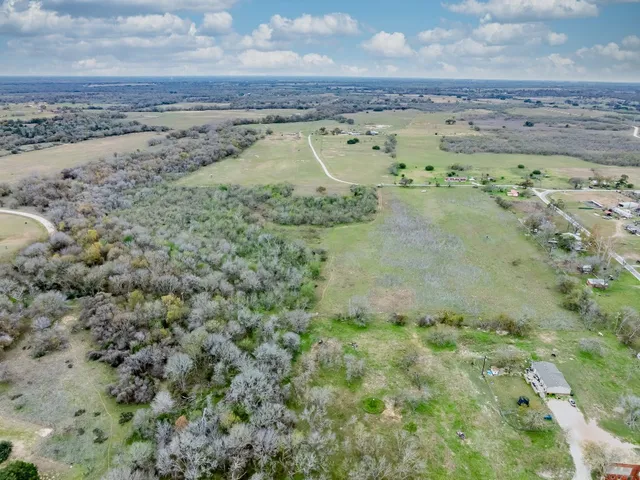 a view of a field with trees and houses
