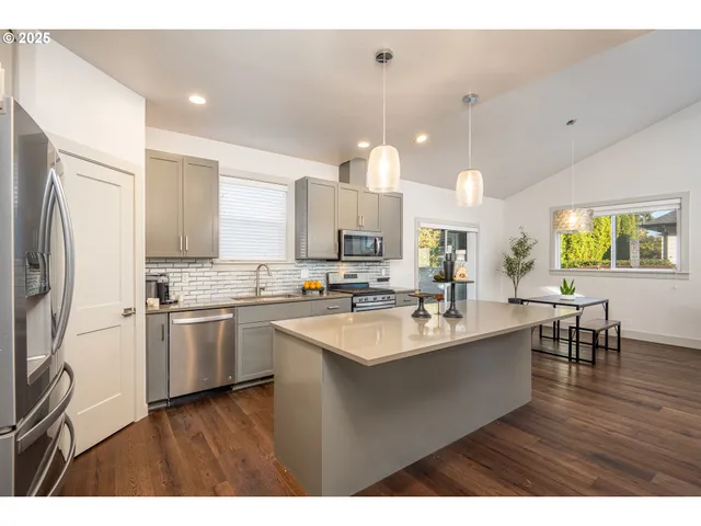 a kitchen with stainless steel appliances granite countertop a sink stove and refrigerator