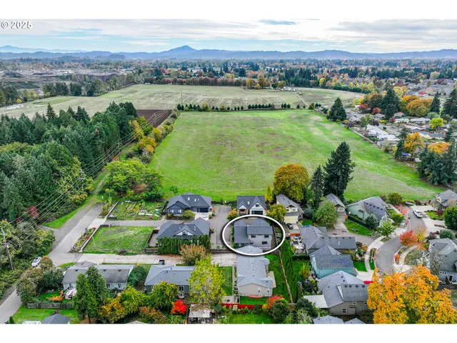 an aerial view of a house with garden space and mountain view in back
