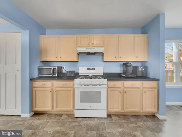 a kitchen with stainless steel appliances granite countertop a stove a sink and a white cabinets
